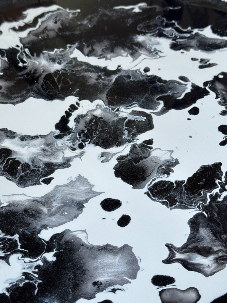 Pavimento em epóxi decorativo com efeito mármore preto e branco, superfície contínua e brilhante.