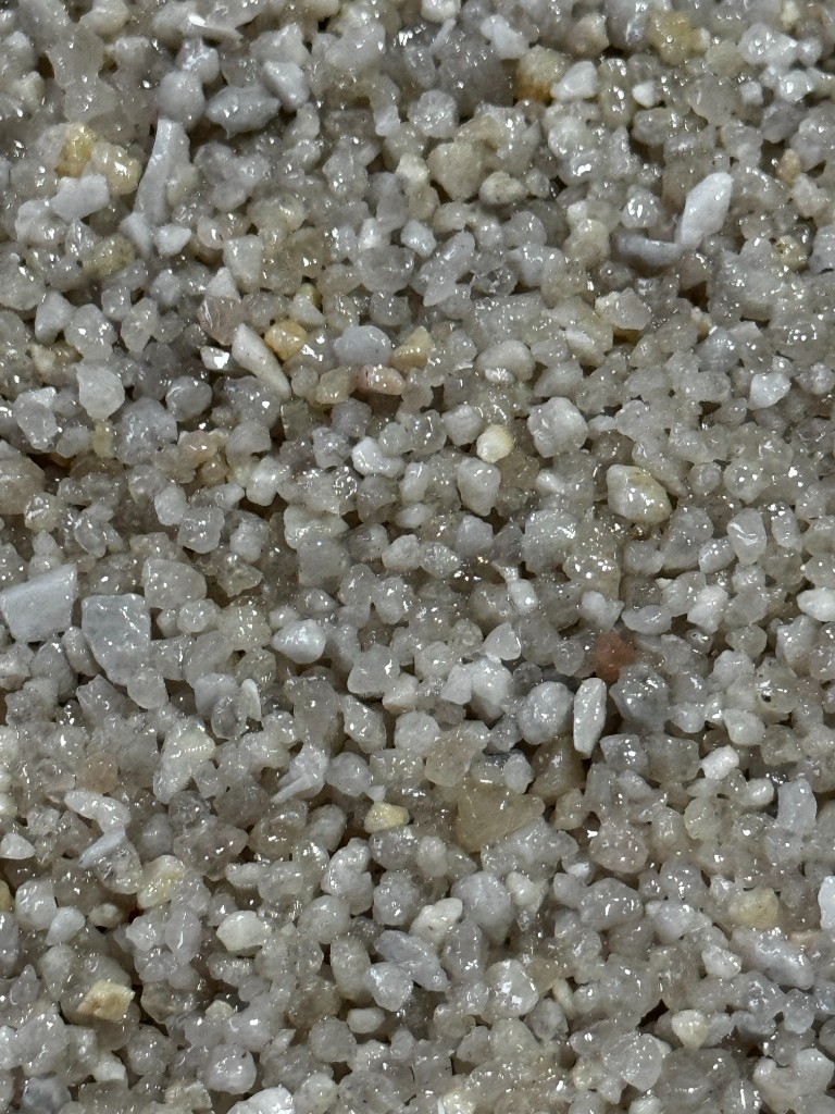 Tapete de Pedra: brita decorativa ligada com resina, textura contínua e aspeto mineral.